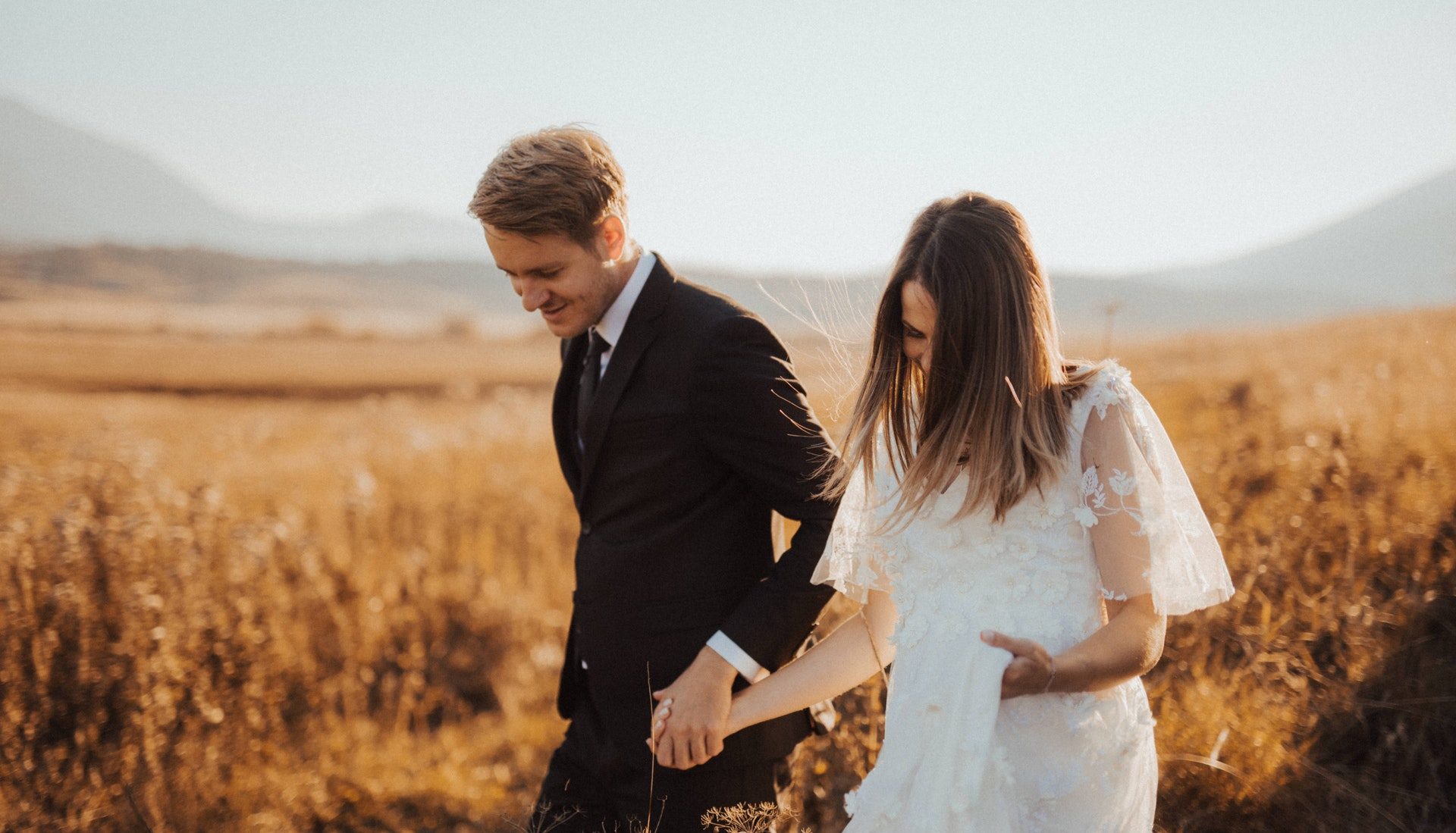 just married couple walking through grass