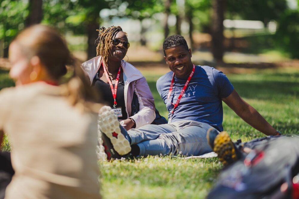 An image of a smiling couple sitting in a group during a Marriage Retreat.
