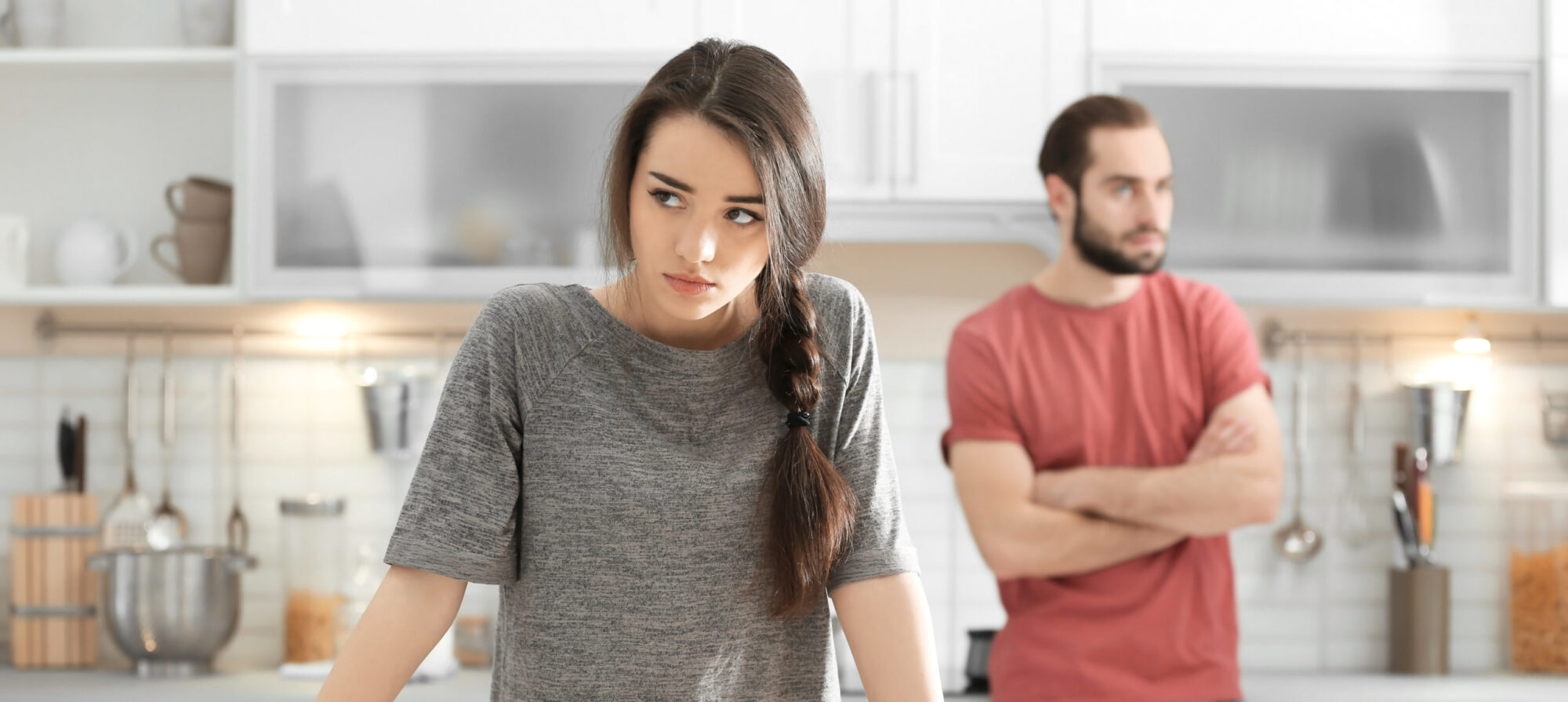 Young couple ignoring each other after having argument in kitchen