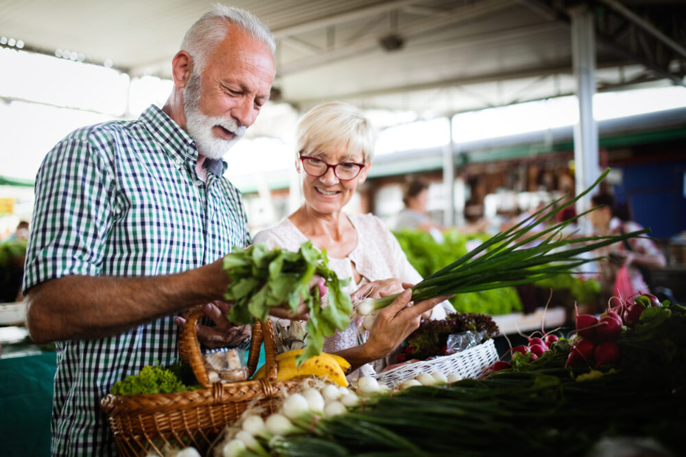 older married couple enjoying one of our spring date ideas, shopping at a farmer's market