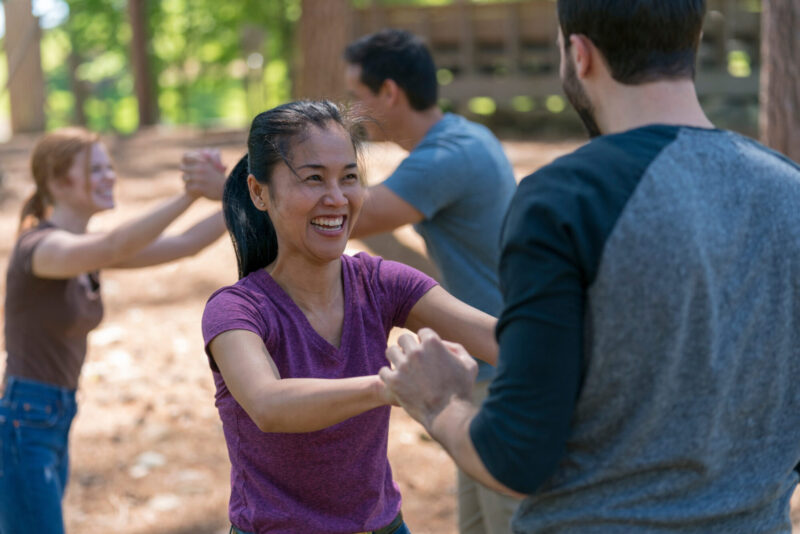 a married couple laughing and holding hands outside at a marriage retreat