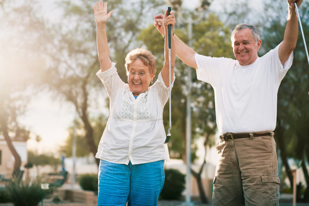 older married couple in the empty nest phase of marriage playing putt putt one of our summer date ideas