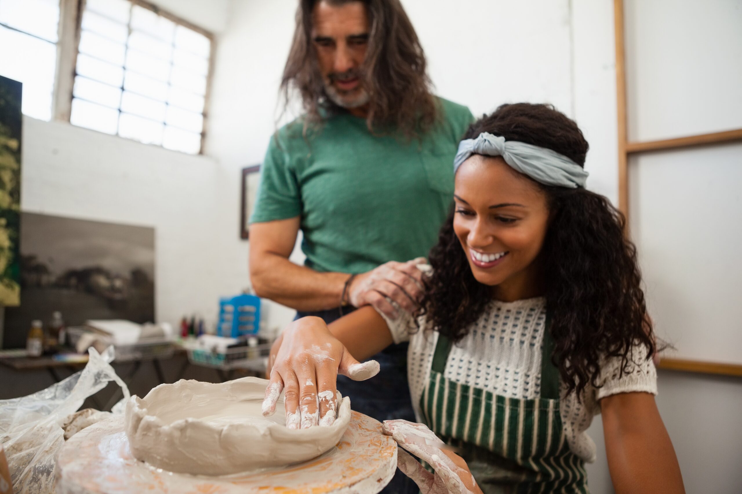 young married couple attending a pottery class one of our summer date ideas