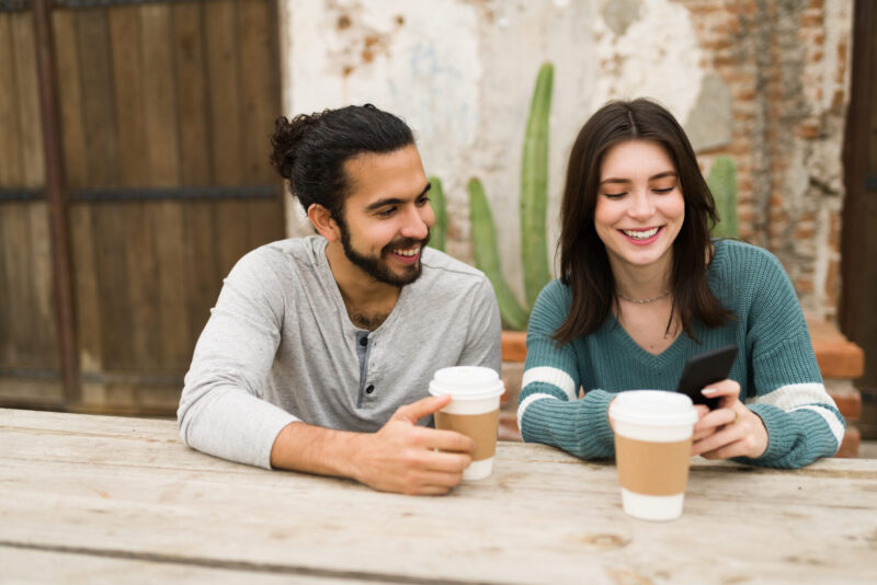 Young couple using free date night conversation starters to have good conversation on a coffee date