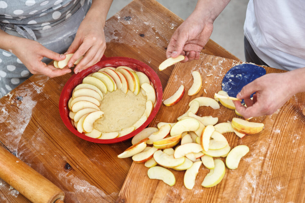 Young married couple making an apple pie together checking off a fall date off their bucket list