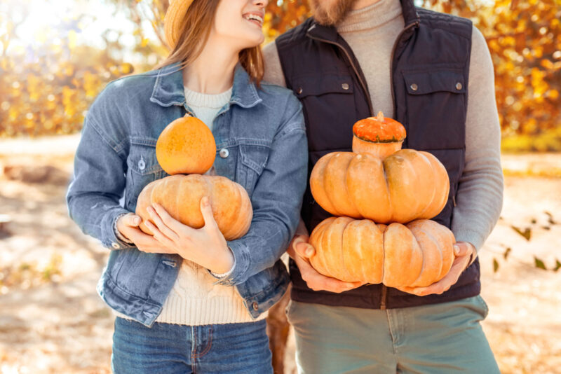 Married couple at a pumpkin patch enjoying a festive fall date together