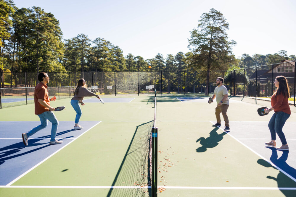 Two younger married couples playing pickleball together at a marriage retreat at WinShape