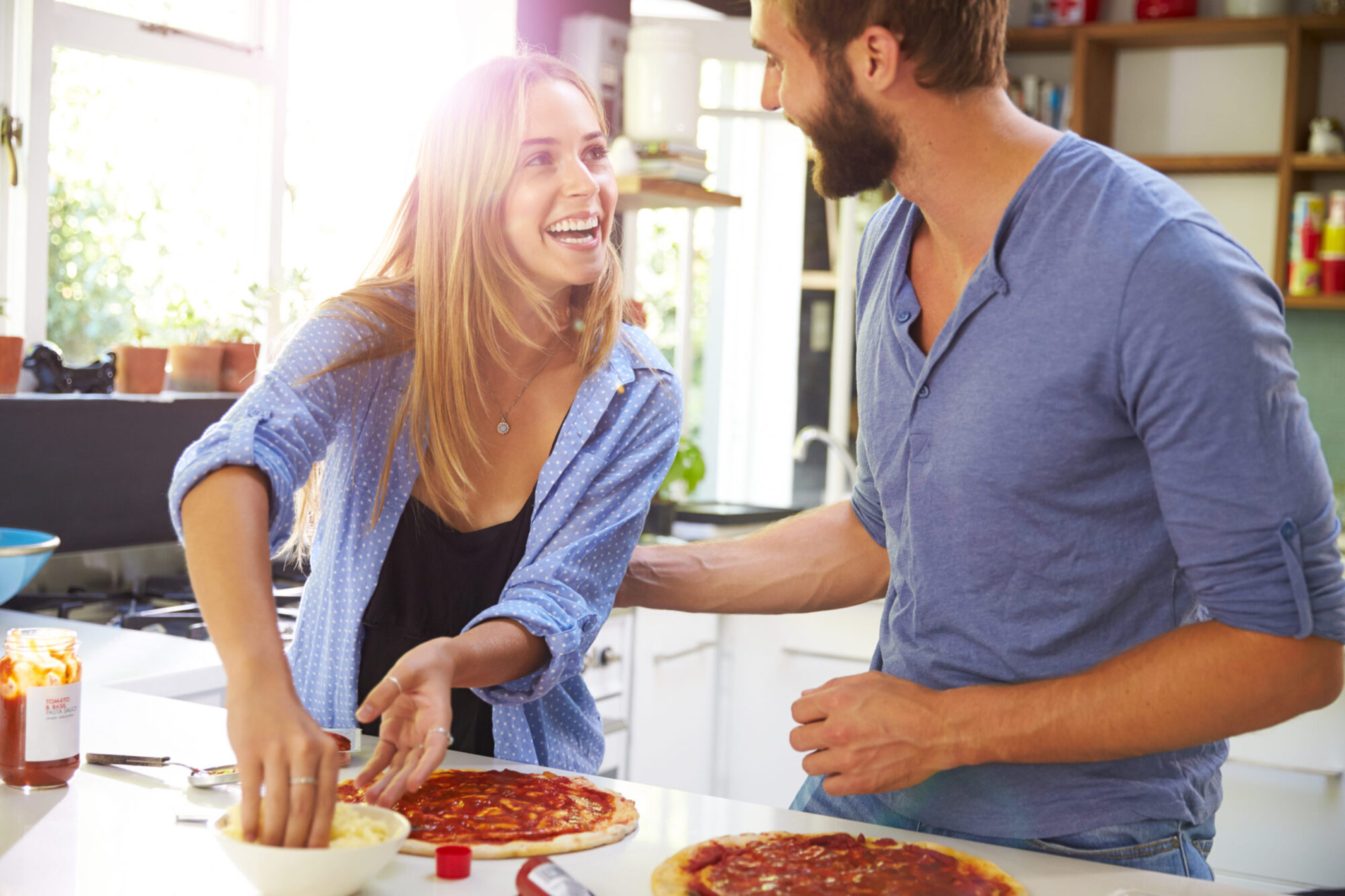 Young married couple choosing to partake in a unique date idea by making homemade pizza together