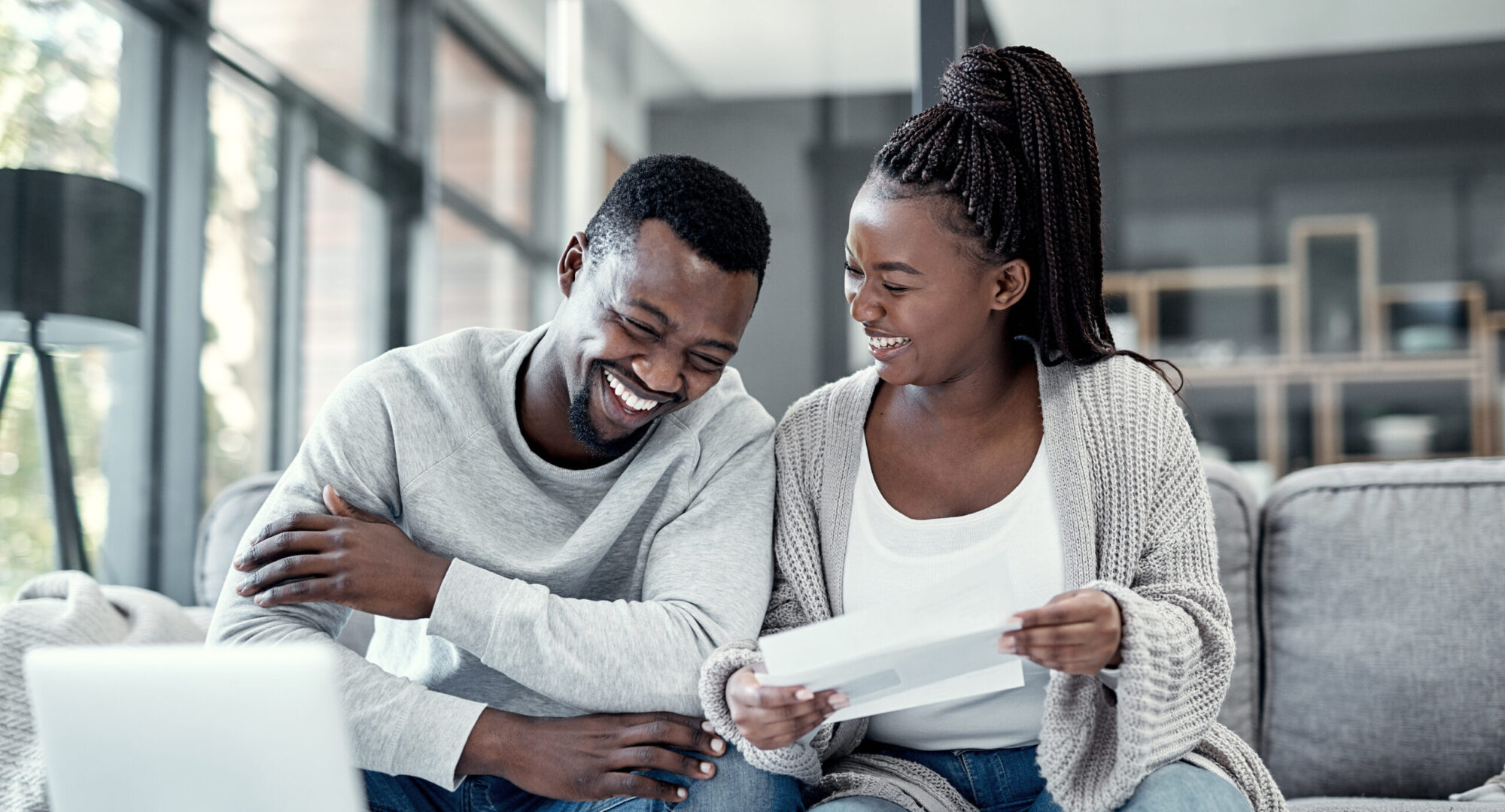 Younger married couple sitting down creating a budget, practicing what they've learned about how to manage money in a marriage