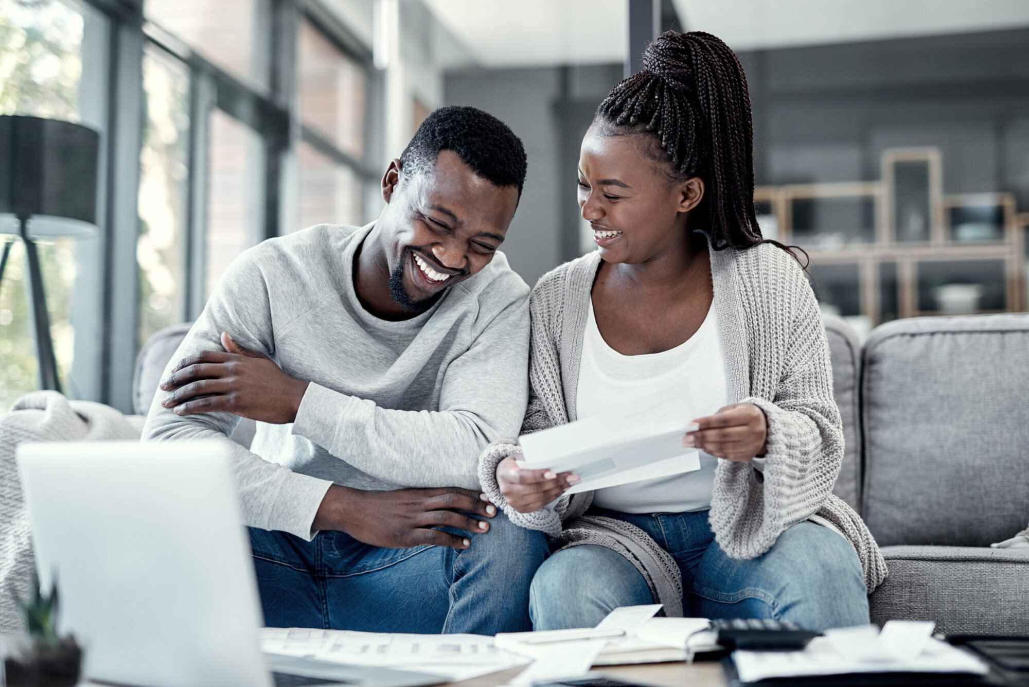 Younger married couple sitting down creating a budget, practicing what they've learned about how to manage money in a marriage