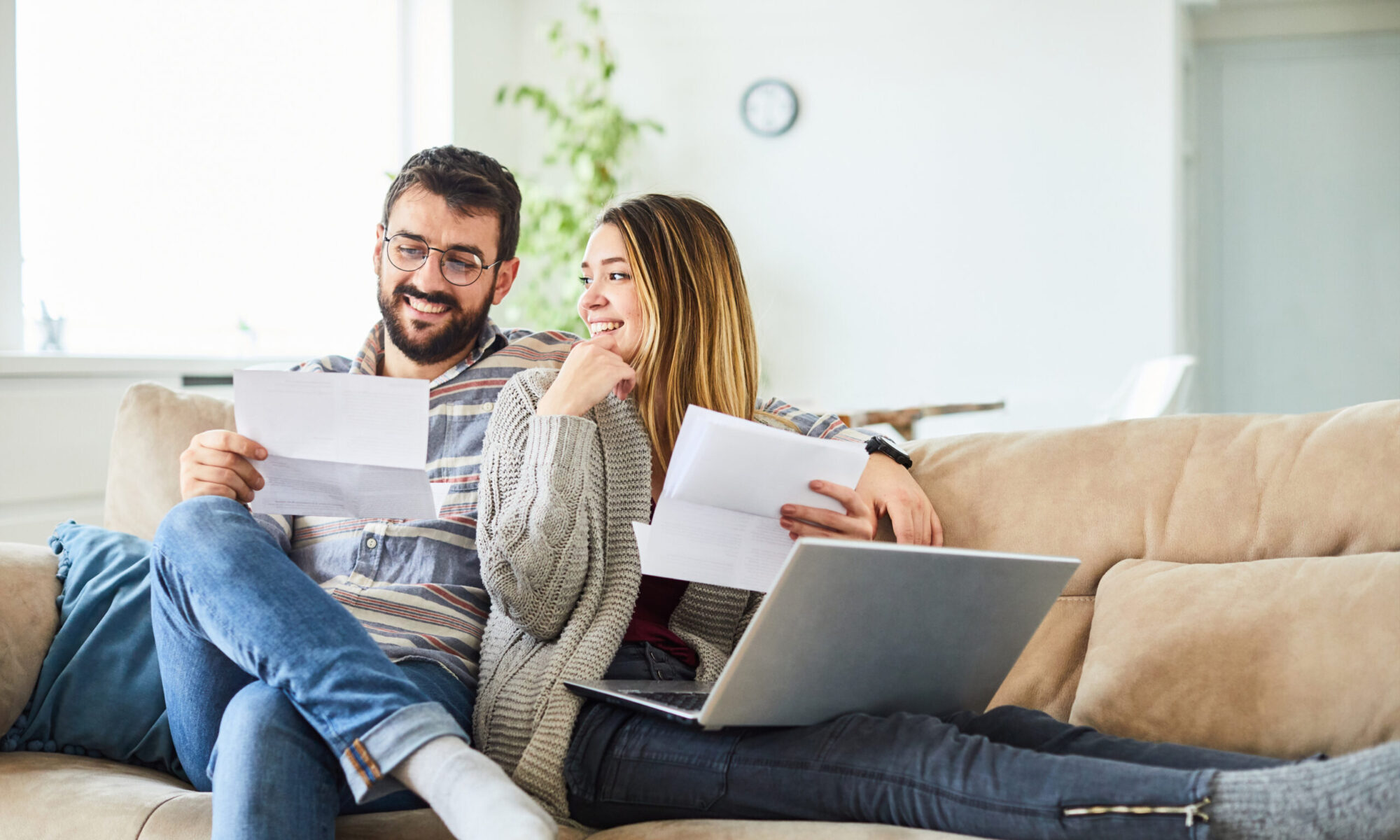 Young engaged couple working through how to talk about finances before marriage, they're using financial conversation starters