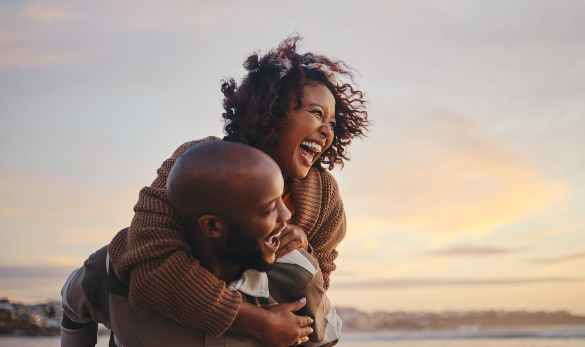 Young married couple on the beach at sunset, having conversation discovering what is the purpose of marriage