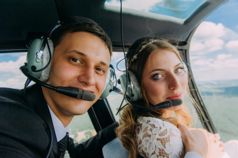 younger married couple riding in a helicopter, one of our 80 date ideas for couples, alphabet date ideas