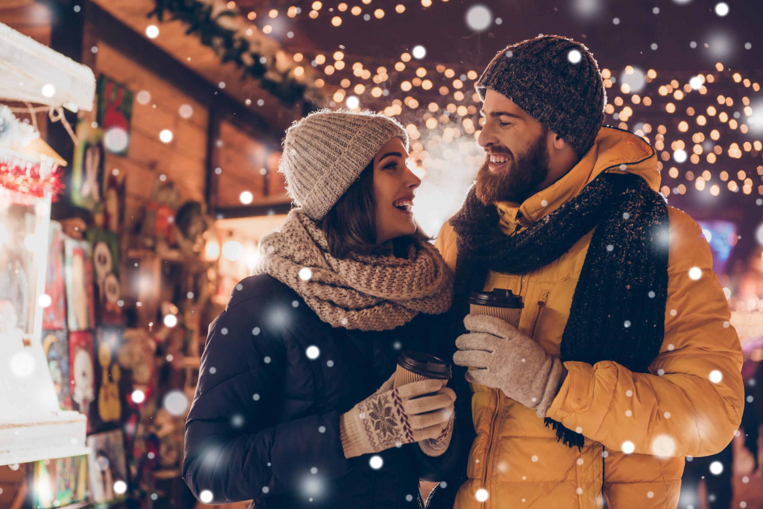 younger married couple going on a winter walk and drinking hot chocolate, one of our 80 date ideas for couples, winter date ideas
