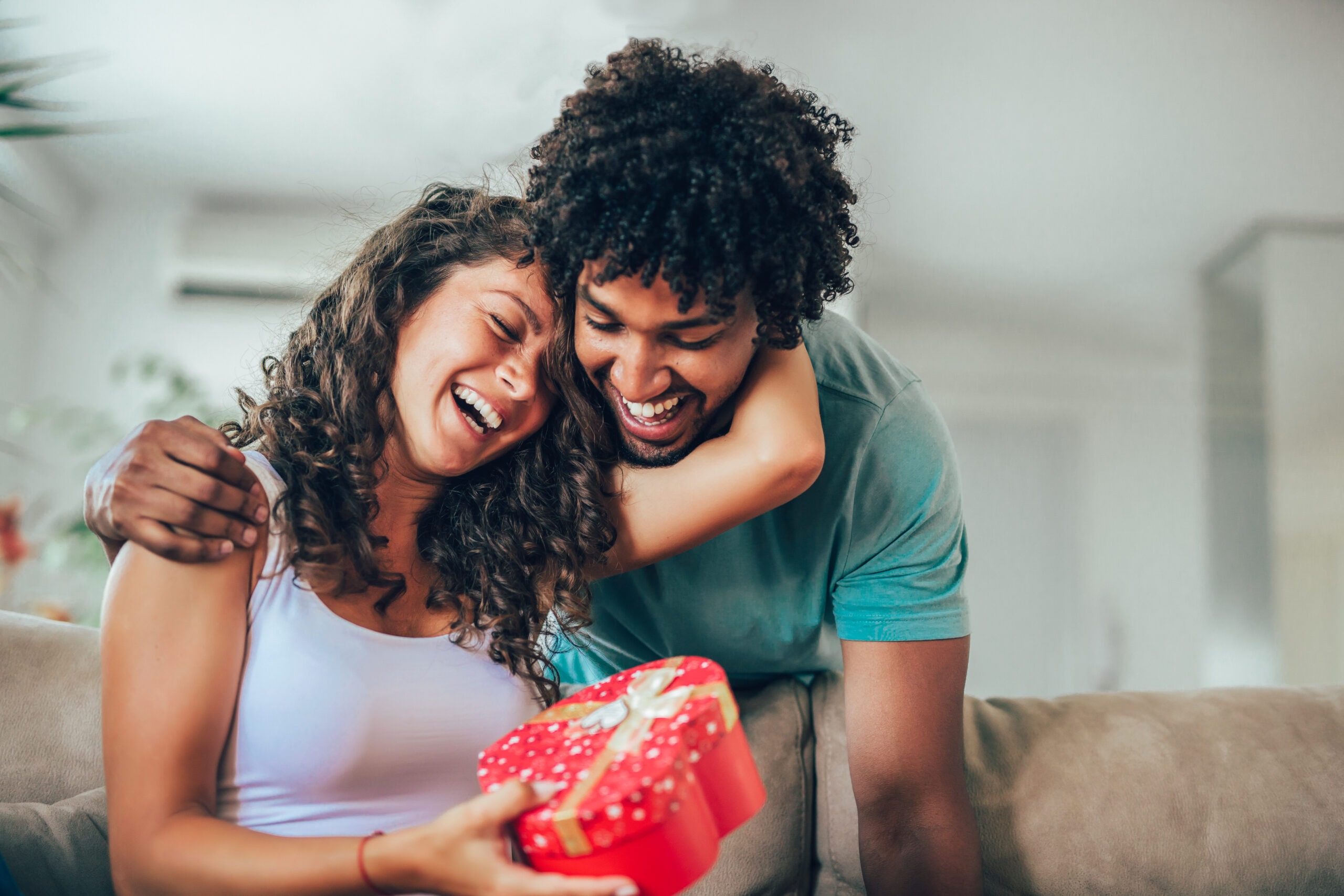 Young married couple, husband using one of our Valentine's Day gifts for her ideas to give a present to his wife