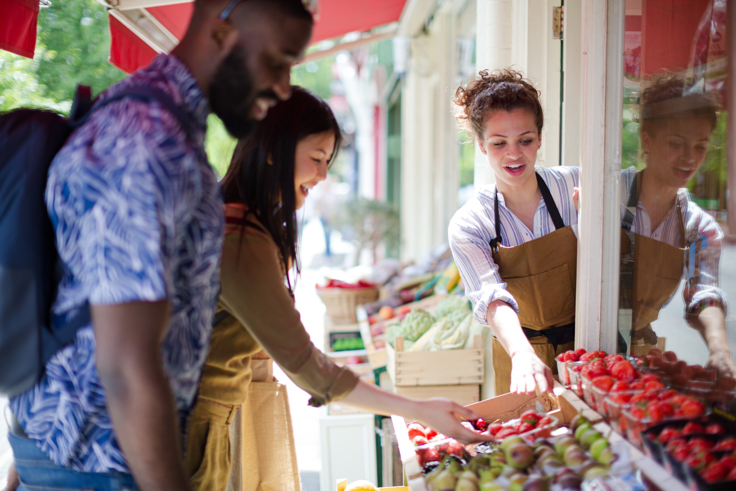 younger married couple shopping at a farmer's market, one of our 80 date ideas for couples, spring date ideas