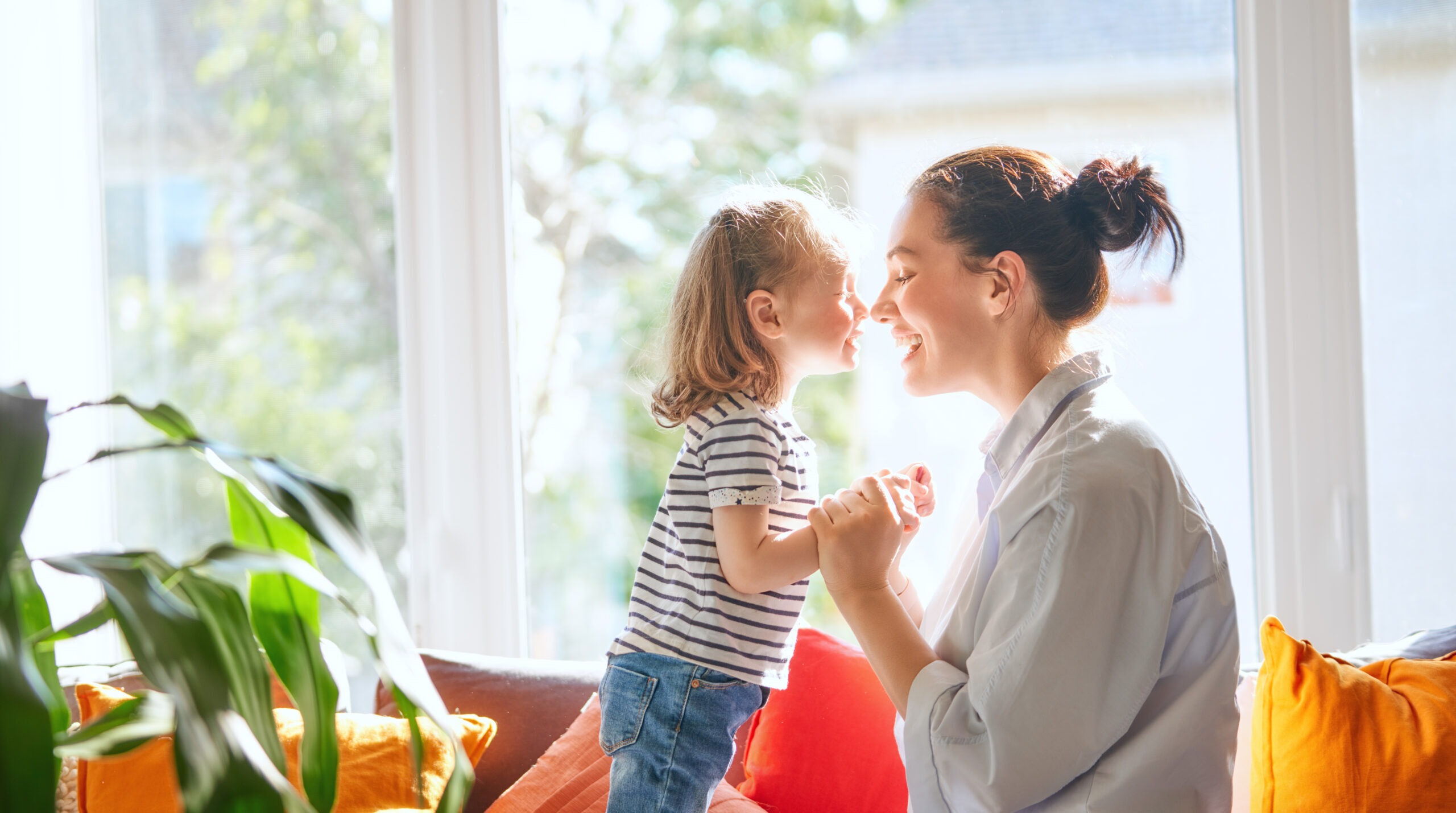 mother and daughter are playing together enjoying a sweet moment; husband is seeking out mother's day gift ideas for his wife