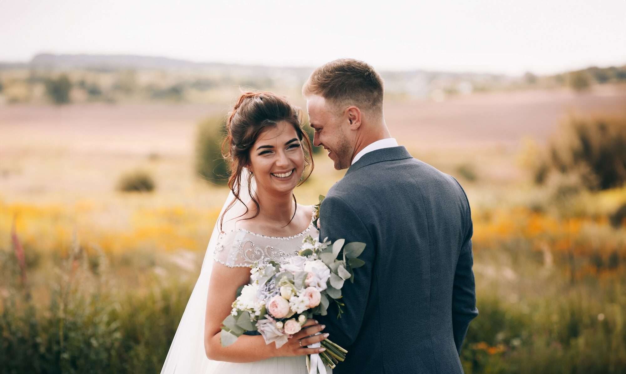 Young man and woman wearing wedding attire and smiling