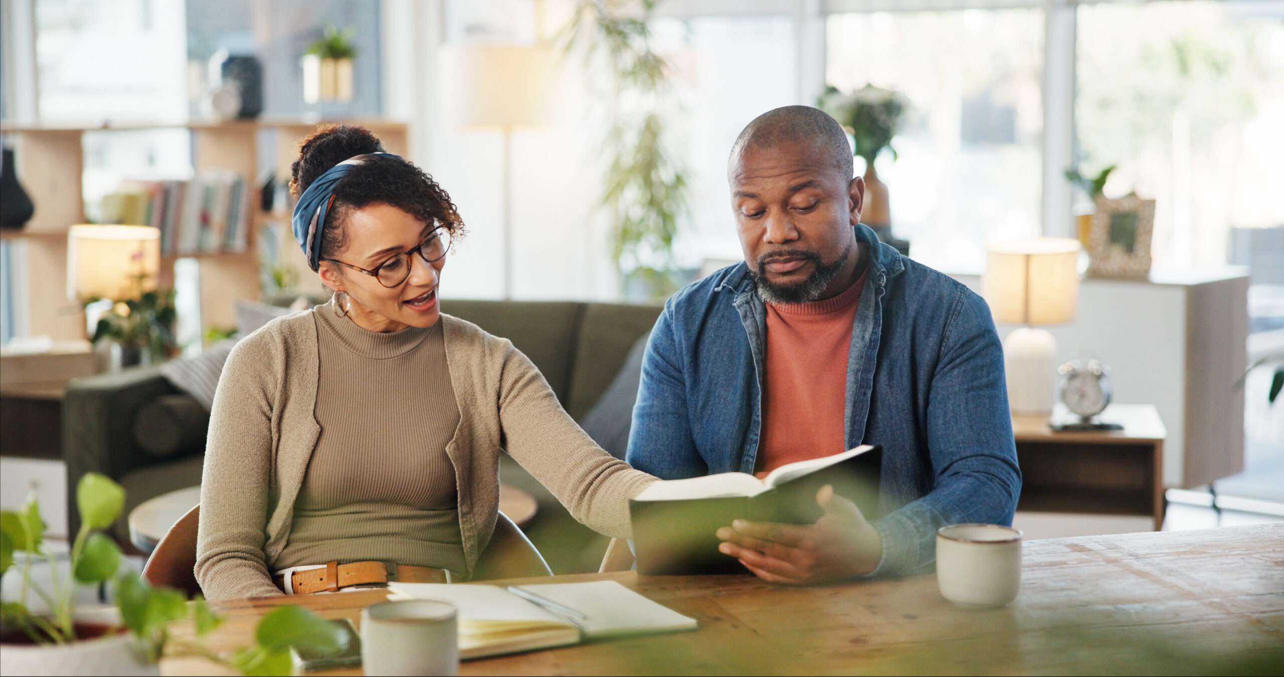 Middle-aged married couple reading Scripture and discussing choosing a church to attend as a couple