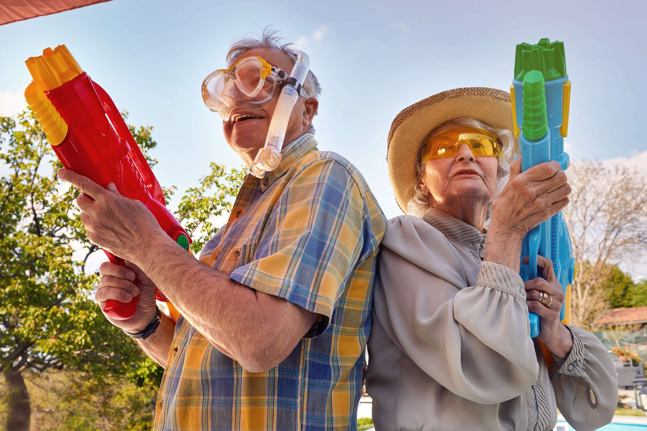 Older married couple having a water gun fight; keeping their marriage young by knowing good games to play with your spouse